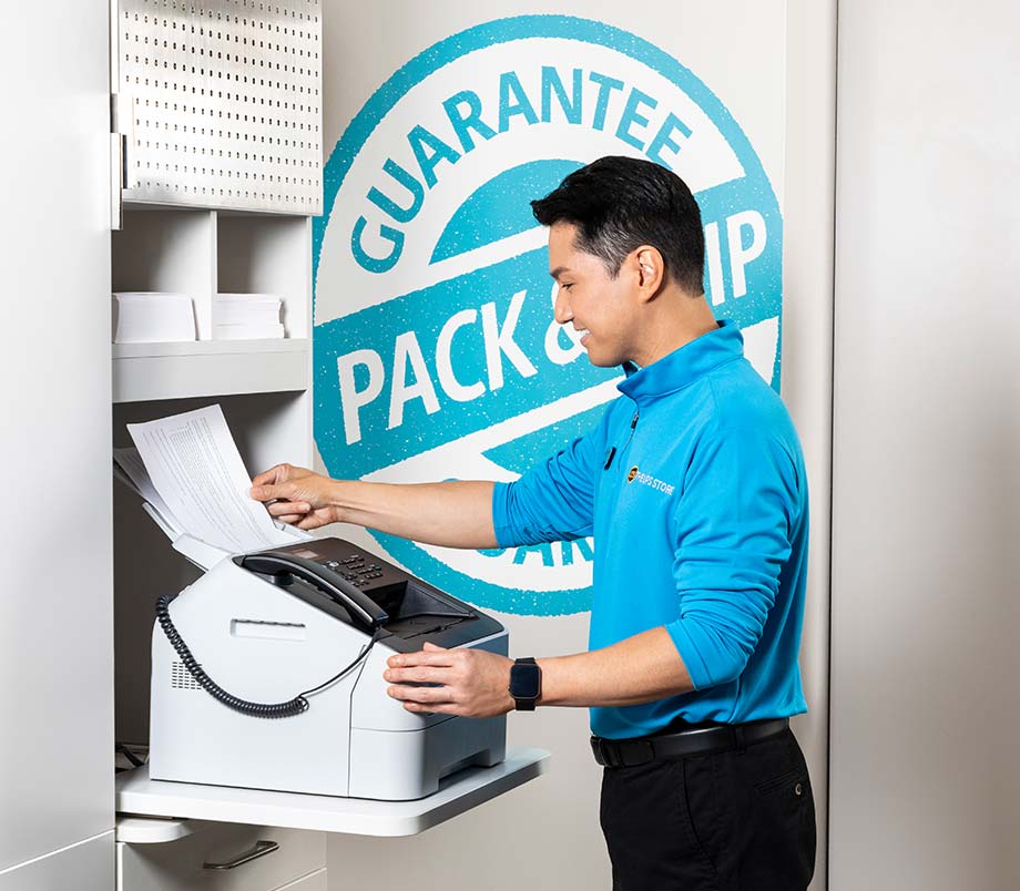 An employee of The UPS Store working with equipment